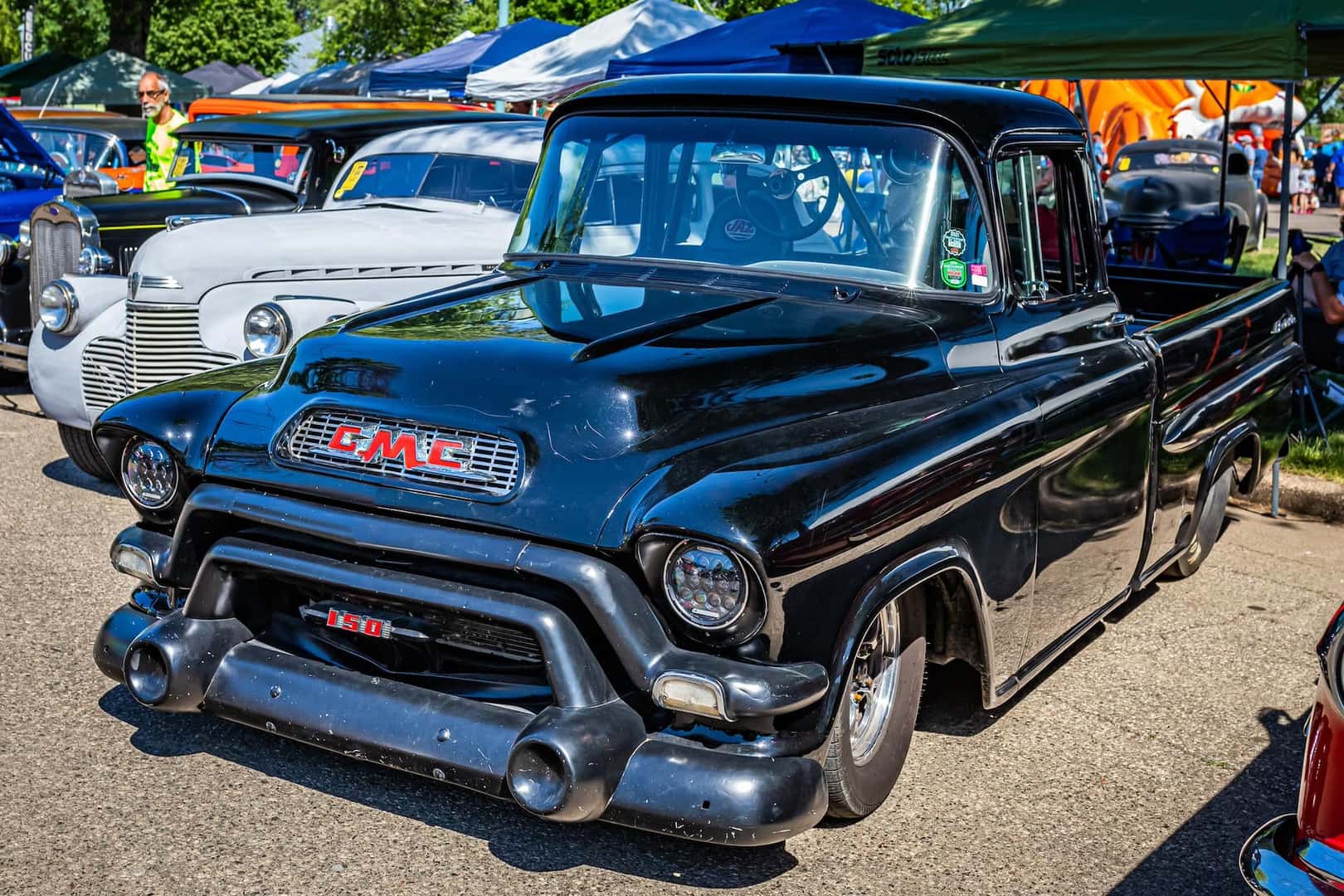 High perspective front corner view of a 1956 GMC 150 Pickup Truck at a local car show.