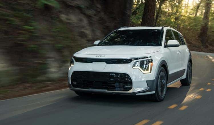 White Kia SUV driving on the road
