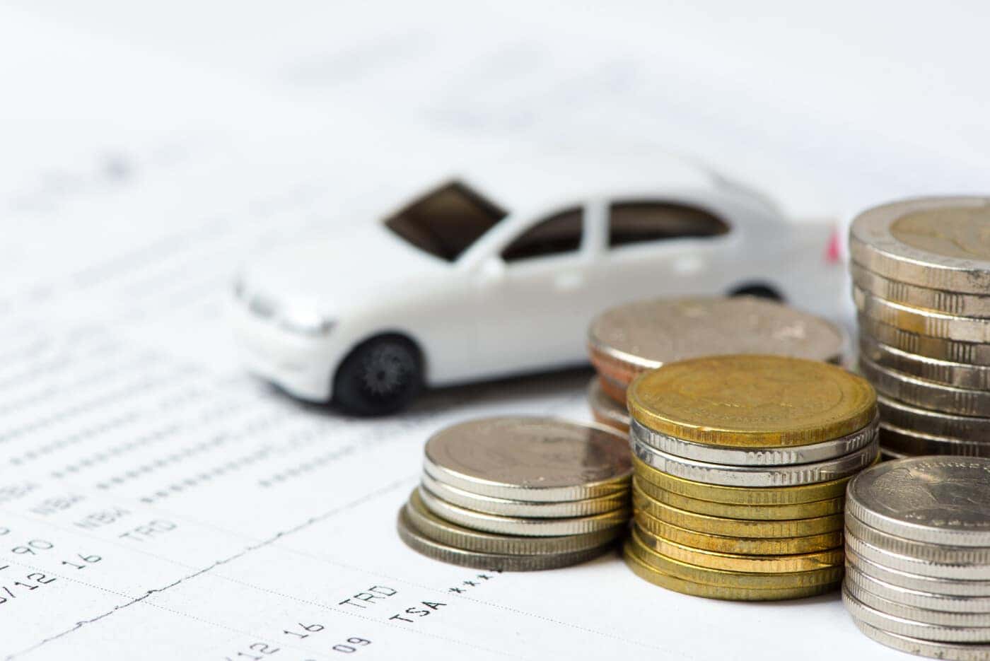 White Car and Coins on a Piece of Paper
