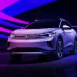 A white 2021 Volkswagen ID.4 is in a dark showroom with pink and blue light streaks.