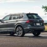 A grey 2021 Volkswagen Tiguan R-Line is parked next to a lake after leaving a Seattle Volkswagen dealership.