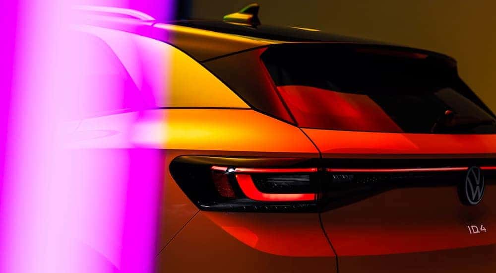 The rear of a white 2022 Volkswagen ID.4 is shown under multicolored lights.