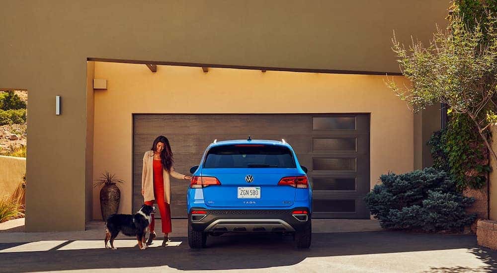 A blue 2022 Volkswagen Taos is shown from the rear parked in a driveway after visiting a Washington Volkswagen dealer.