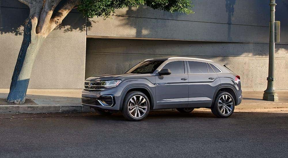 A grey 2022 Volkswagen Atlas Cross Sport is shown parked outside of a Bellevue VW dealership.