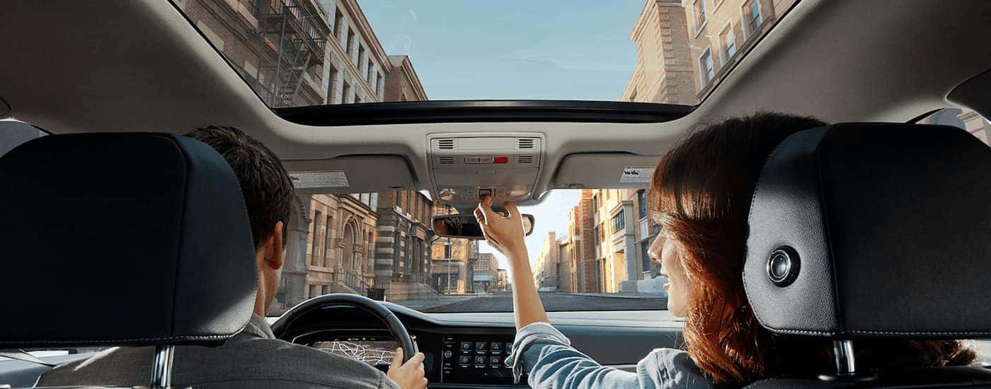 A woman is shown opening the sunroof in a 2022 Volkswagen Jetta.