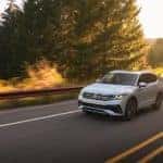 A white 2022 Volkswagen Tiguan is shown driving on an open road.