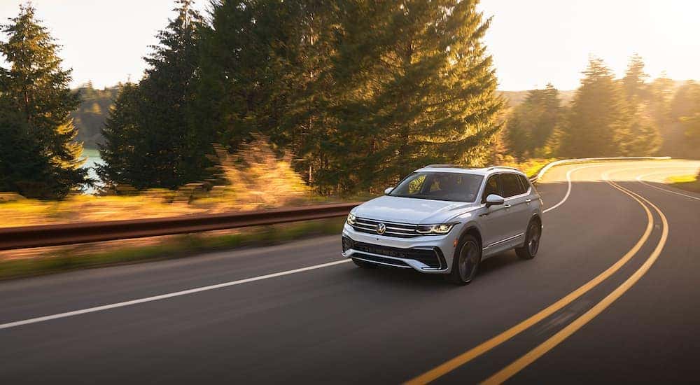 A white 2022 Volkswagen Tiguan is shown driving on an open road.