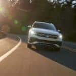 A white 2022 Volkswagen Tiguan SEL R-Line is shown from the front on a sunny road after visiting a Burien Volkswagen dealer.