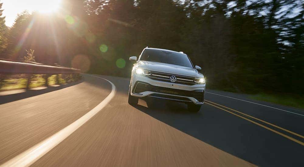 A white 2022 Volkswagen Tiguan SEL R-Line is shown from the front on a sunny road after visiting a Burien Volkswagen dealer.