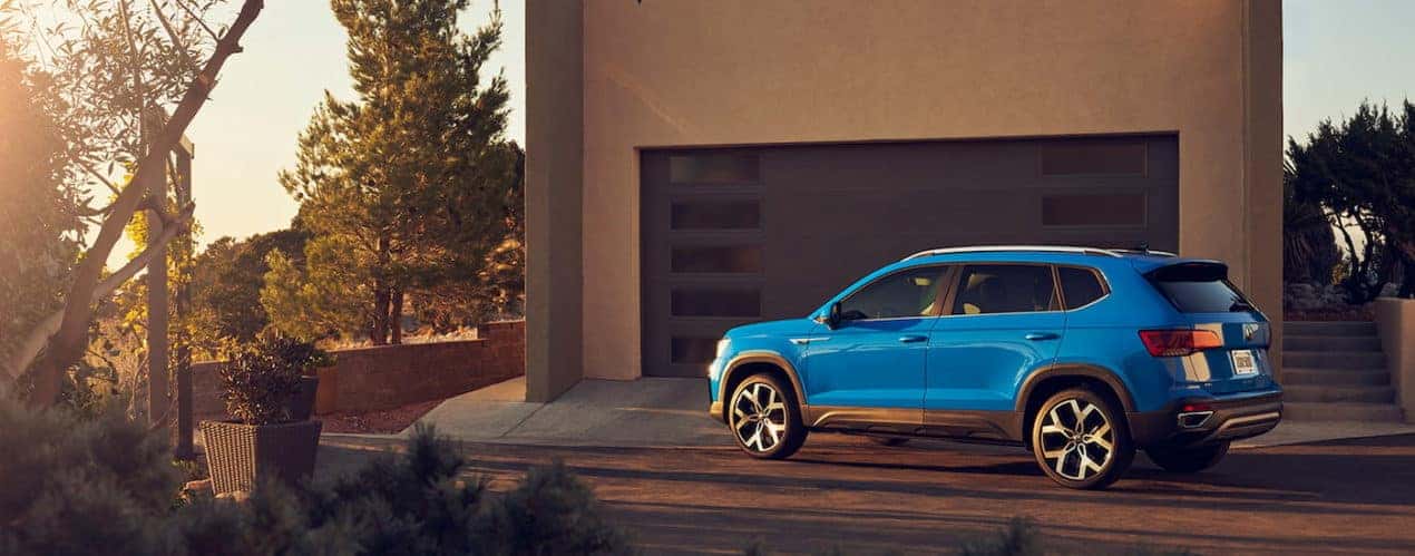 A blue 2022 Volkswagen Taos SEL is shown parked in a driveway.