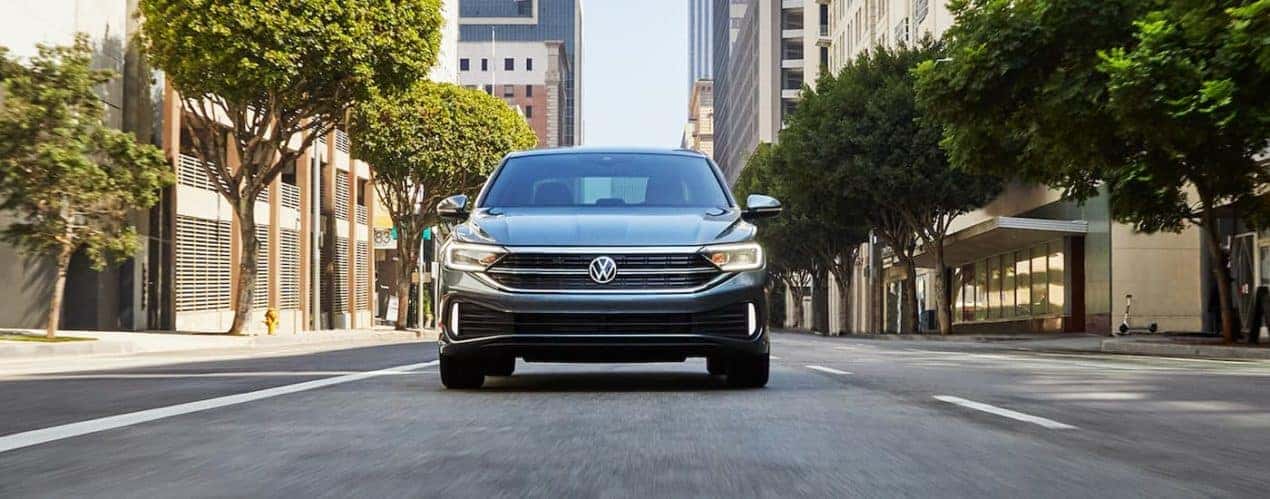 A grey 2022 Volkswagen Jetta SEL is shown from the front driving on an open road.