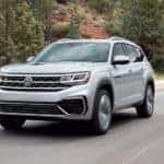 A silver 2022 Volkswagen Atlas SE is shown driving on an open road.