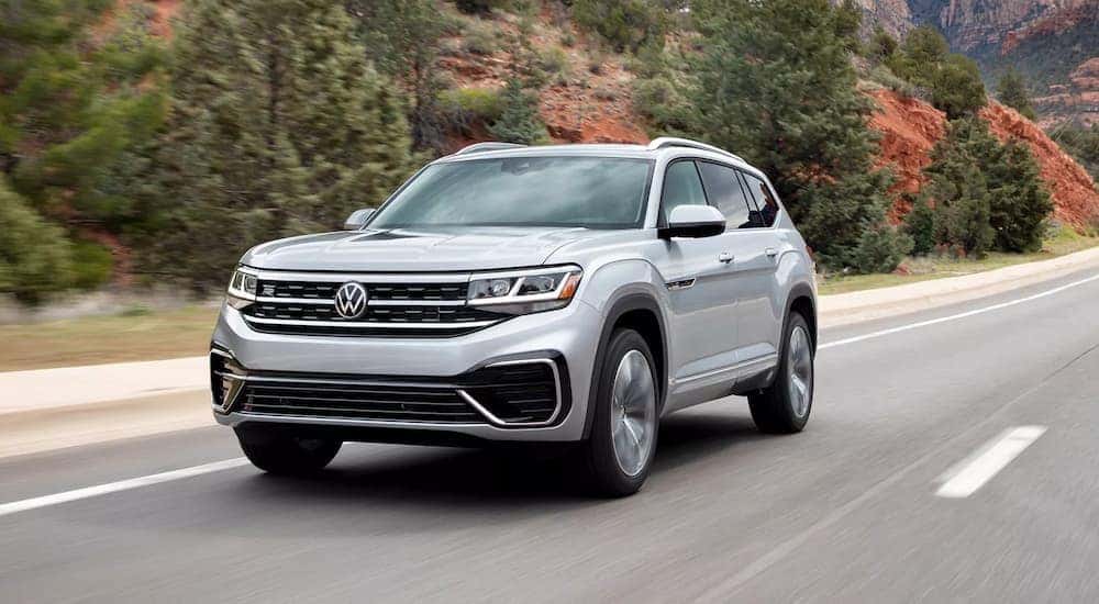 A silver 2022 Volkswagen Atlas SE is shown driving on an open road.