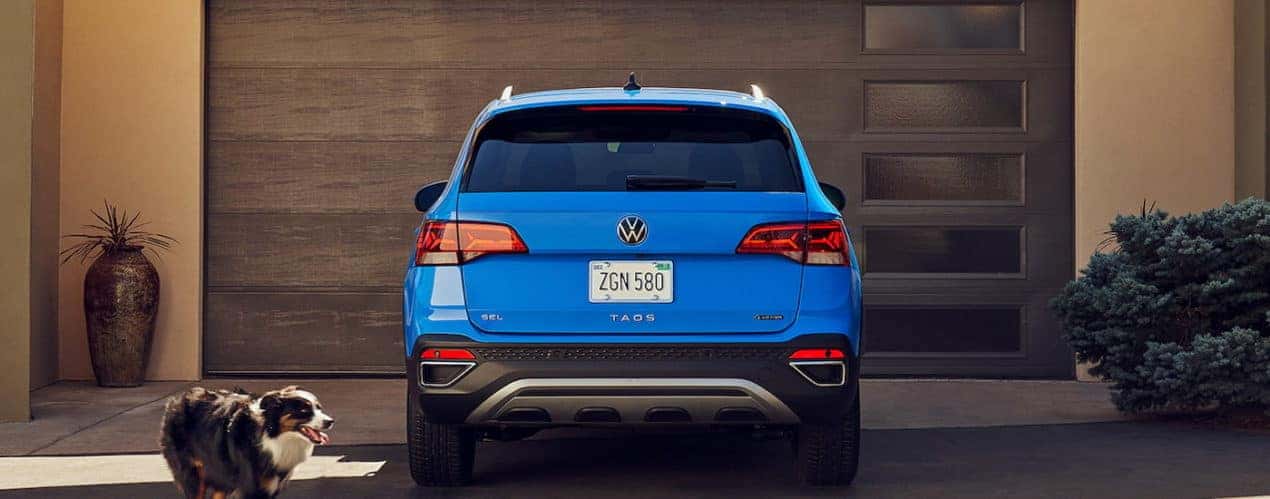 A blue 2022 Volkswagen Taos is shown from the rear while parked in a driveway.