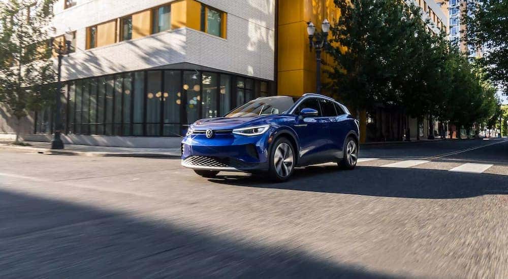 A blue 2023 Volkswagen ID.4 is shown driving on a city street.