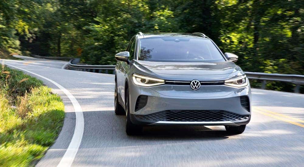 A grey 2023 Volkswagen ID.4 is shown on a tree-lined road after leaving a Renton, WA VW ID.4 dealer.