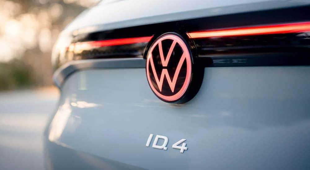 A close up shows the illuminated Volkswagen badge on the trunk of a grey 2023 Volkswagen ID.4.