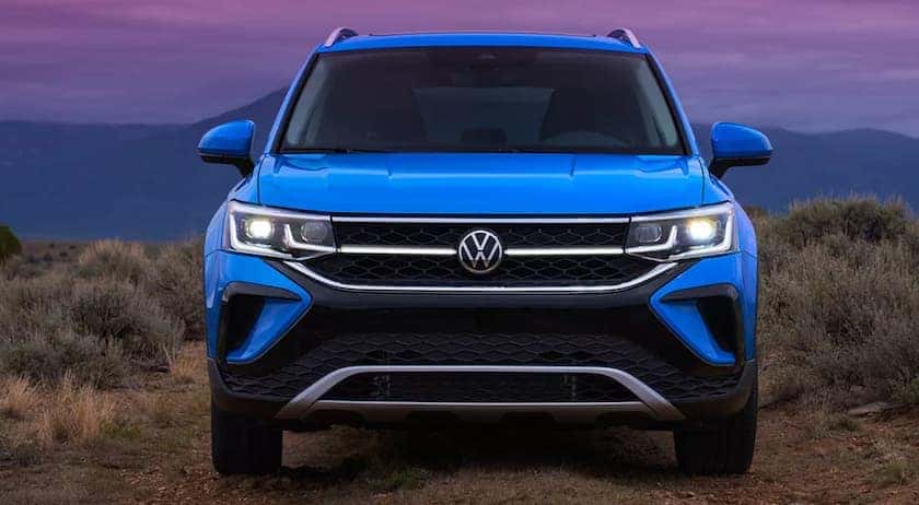 A blue 2023 Volkswagen Taos is shown from the front.