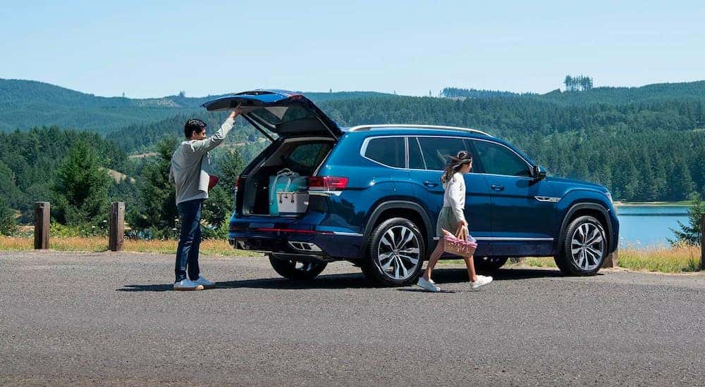 People are shown getting ready for a picnic near a dark blue 2023 Volkswagen Atlas.