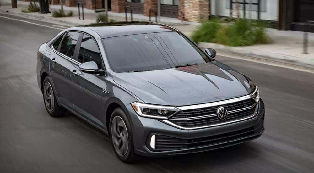 A grey 2023 Volkswagen Jetta SEL is shown from the front driving on an open road.