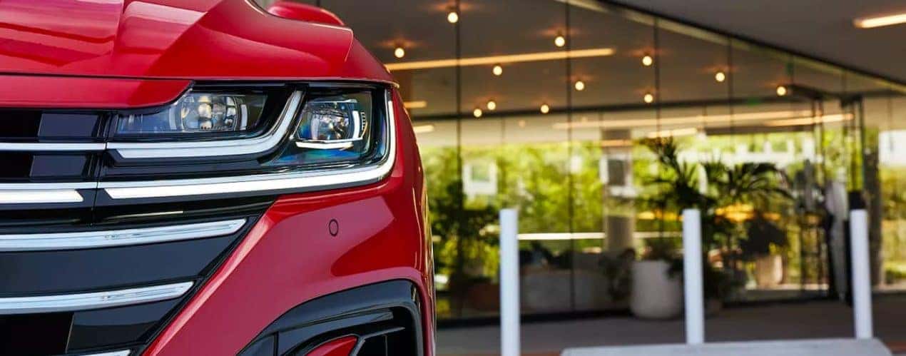 A close up shows the driver side headlight on a red 2023 Volkswagen Arteon.