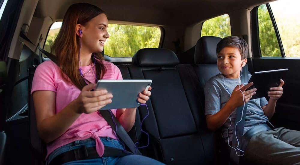 Kids are shown using tablets and smiling in a 2023 Volkswagen Arteon.
