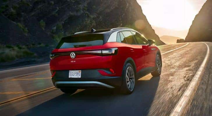 A red 2021 Volkswagen ID.4 is shown on a mountain road after leaving a Certified VW dealer.