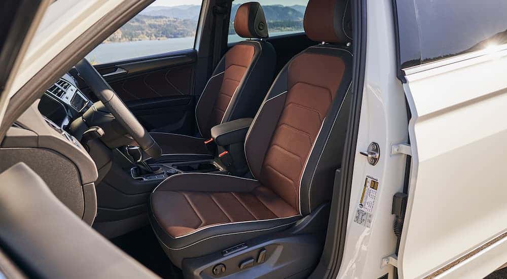 The black and brown interior of a white 2023 Volkswagen Tiguan is shown.