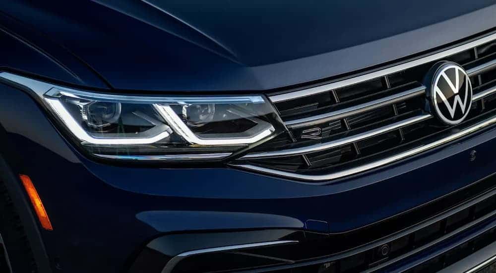A close up on the grille of a dark blue 2023 Volkswagen Tiguan R-Line is shown.