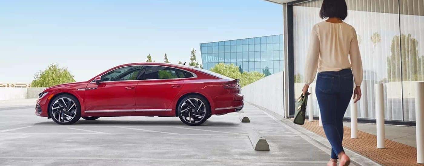 A person is shown walking toward a red 2022 Volkswagen Arteon SEL Premium R-Line.