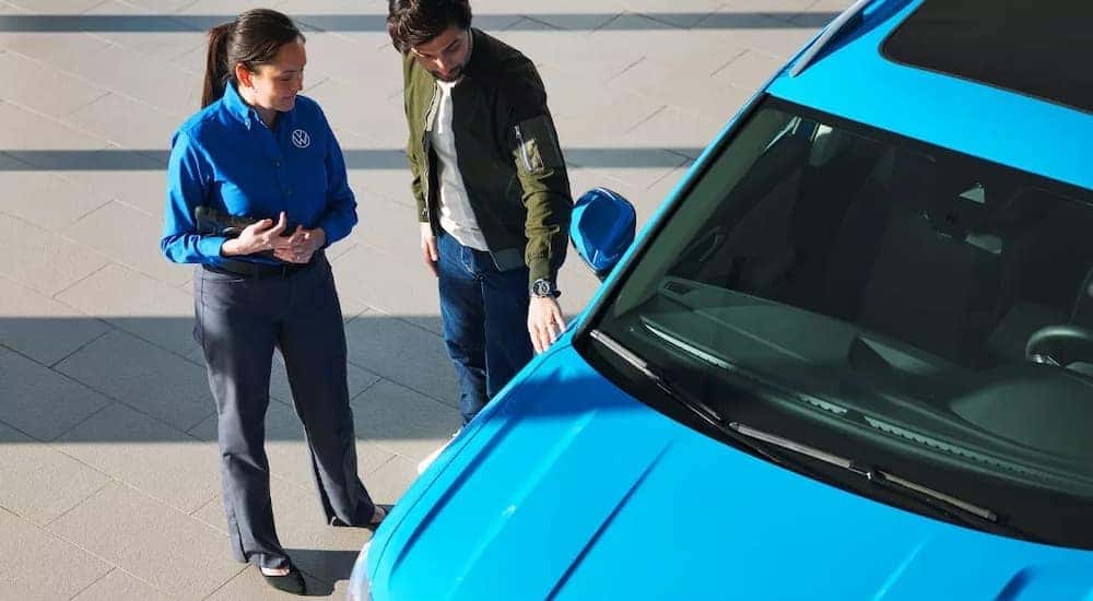 An employee at Bud Clary Auburn Volkswagen is shown assisting a customer find VW lease deals.