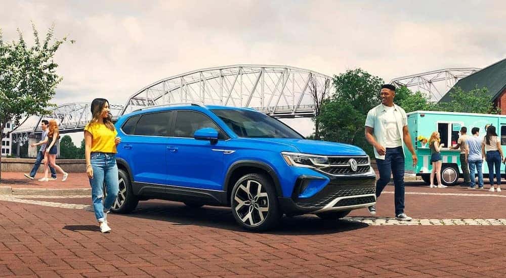 A blue 2023 Volkswagen Taos is shown parked near a bridge after winning a 2023 Volkswagen Taos vs 2023 Toyota Corolla Cross comparison.