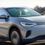 A light blue 2023 Volkswagen ID.4 is shown driving on a road after winning a 2023 Volkswagen ID.4 Electric Vehicle vs 2023 Tesla Model Y comparison.