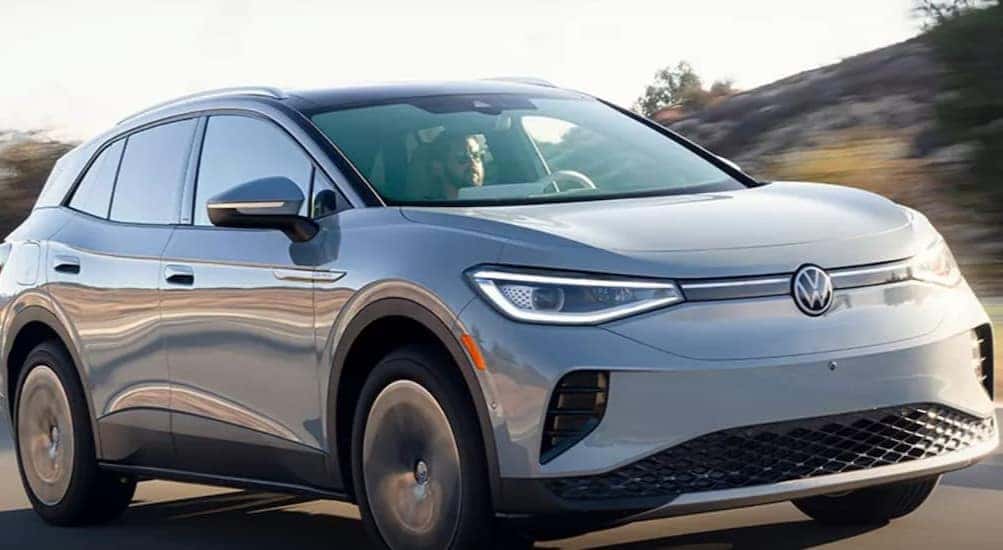 A light blue 2023 Volkswagen ID.4 is shown driving on a road after winning a 2023 Volkswagen ID.4 Electric Vehicle vs 2023 Tesla Model Y comparison.