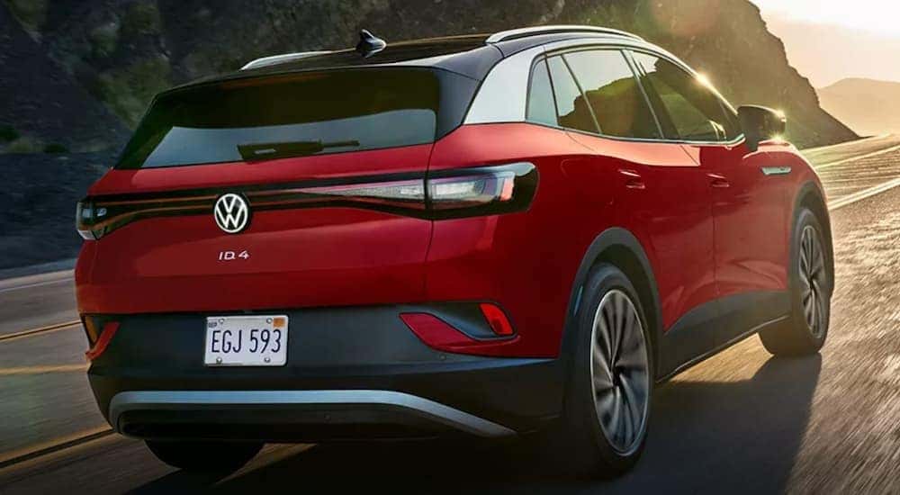 A red 2023 Volkswagen ID.4 is shown driving on a highway.