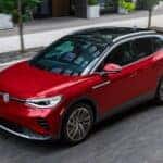 A red and black 2023 Volkswagen ID.4 is shown driving on a city street after winning a 2023 Volkswagen ID.4 Electric Vehicle vs 2023 Ford Mustang Mach-E comparison.