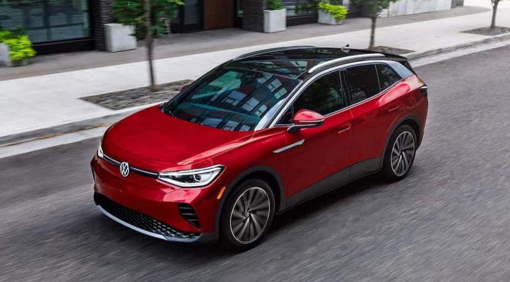 A red and black 2023 Volkswagen ID.4 is shown driving on a city street after winning a 2023 Volkswagen ID.4 Electric Vehicle vs 2023 Ford Mustang Mach-E comparison.