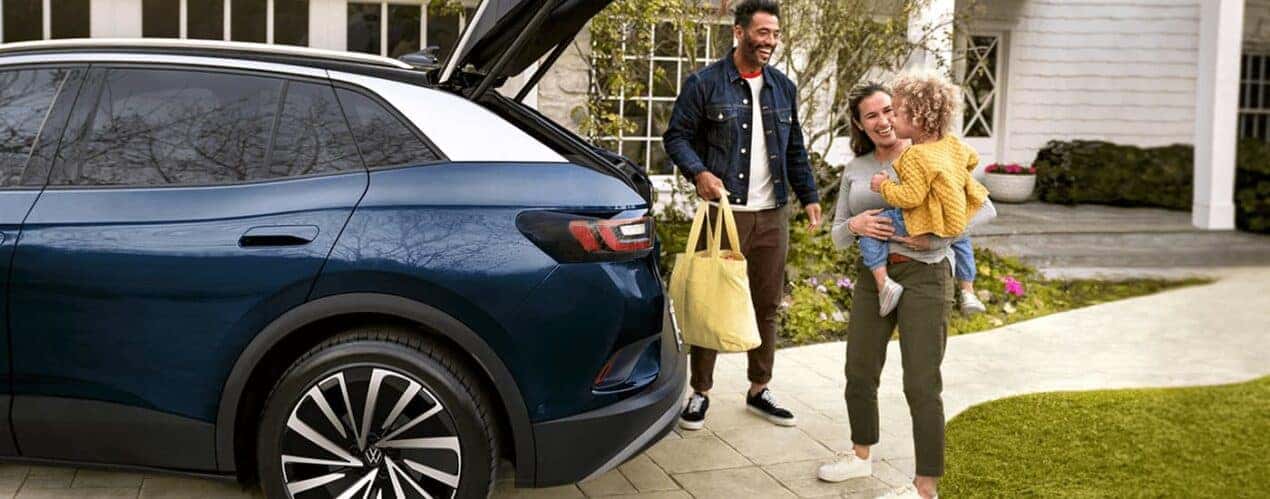 A family is shown putting cargo into the back of a 2023 Volkswagen ID.4.