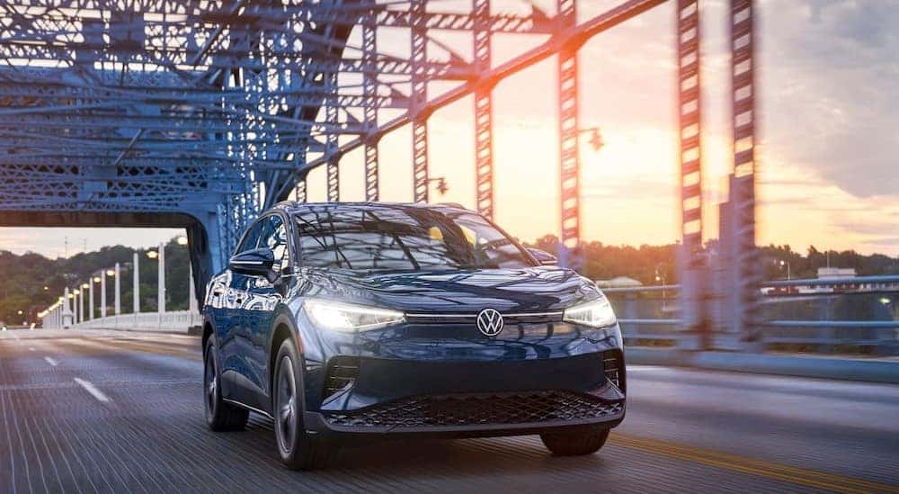 A blue 2023 Volkswagen ID.4 is shown driving on a bridge.