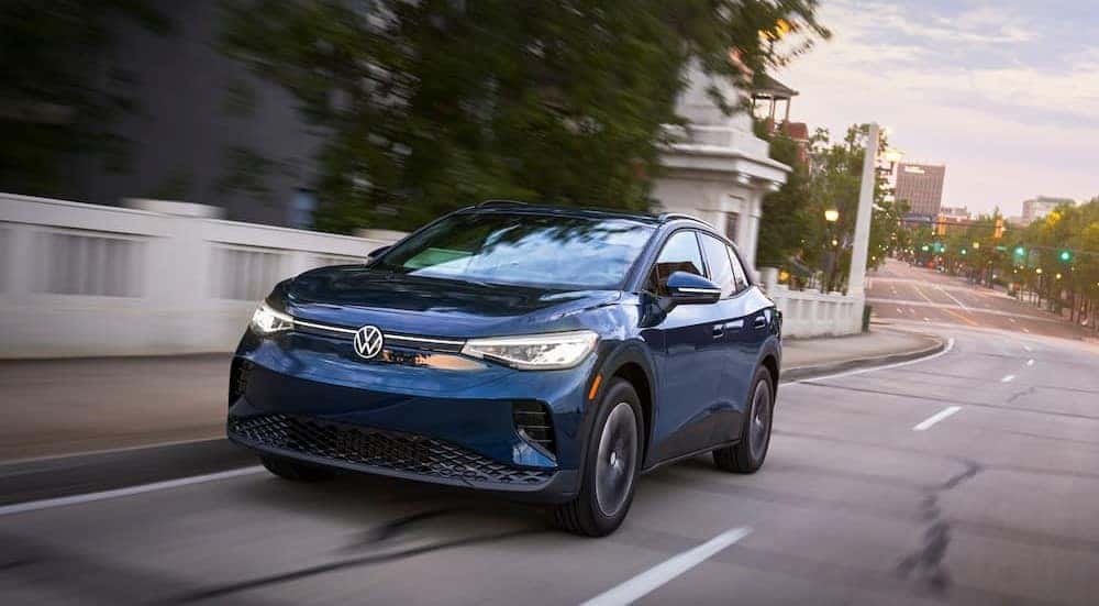 A blue 2023 Volkswagen ID.4 is shown driving on a bridge after visiting a Puyallup VW dealer.