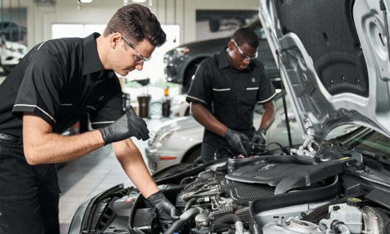 Mercedes-Benz Service Technicians Working Under Hood