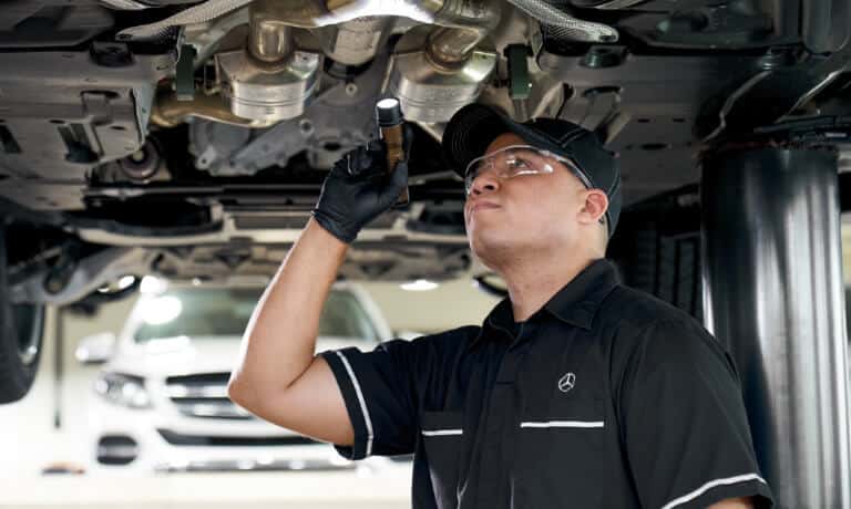 Mercedes Service Technician Inspecting Under Vehicle