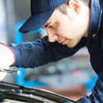 Portrait of an auto mechanic at work on a car in his garage