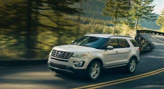 Ford SUV driving on highway in forest