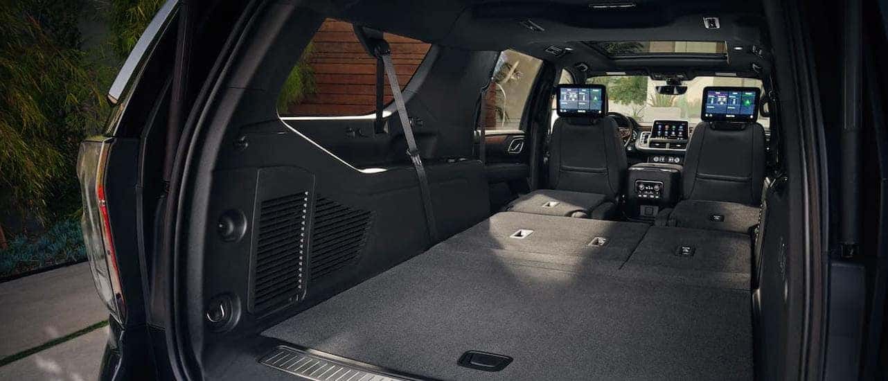 The cargo area of a 2021 Chevy Suburban is shown with the rear seats folded down.