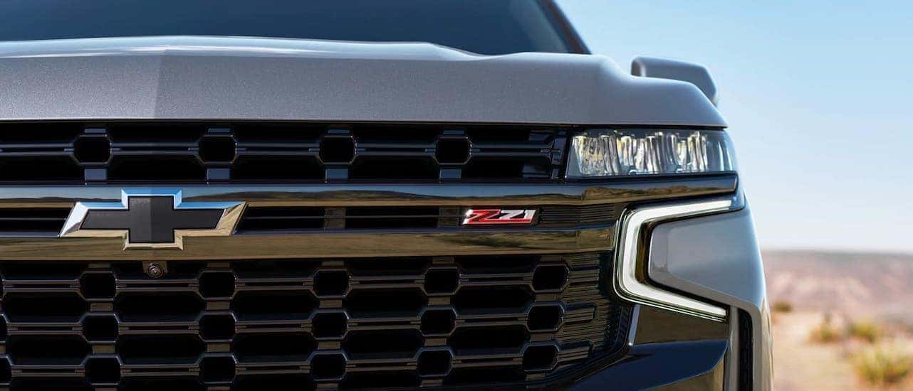 A closeup shows the Z71 badging and black bowtie on a gray 2021 Chevy Suburban near Lexington, KY.