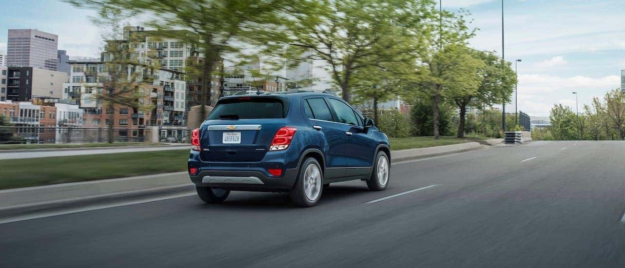 A blue 2021 Chevy Trax Premier is driving away on a highway near Lexington, KY.