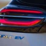 The rear badging is shown under the taillight of a silver 2022 Chevy Bolt EV, one of the Chevy electric vehicles.