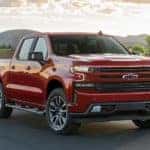 A red 2021 Chevy Silverado 1500 is parked next to a field after leaving a Lexington Chevy Silverado dealer.