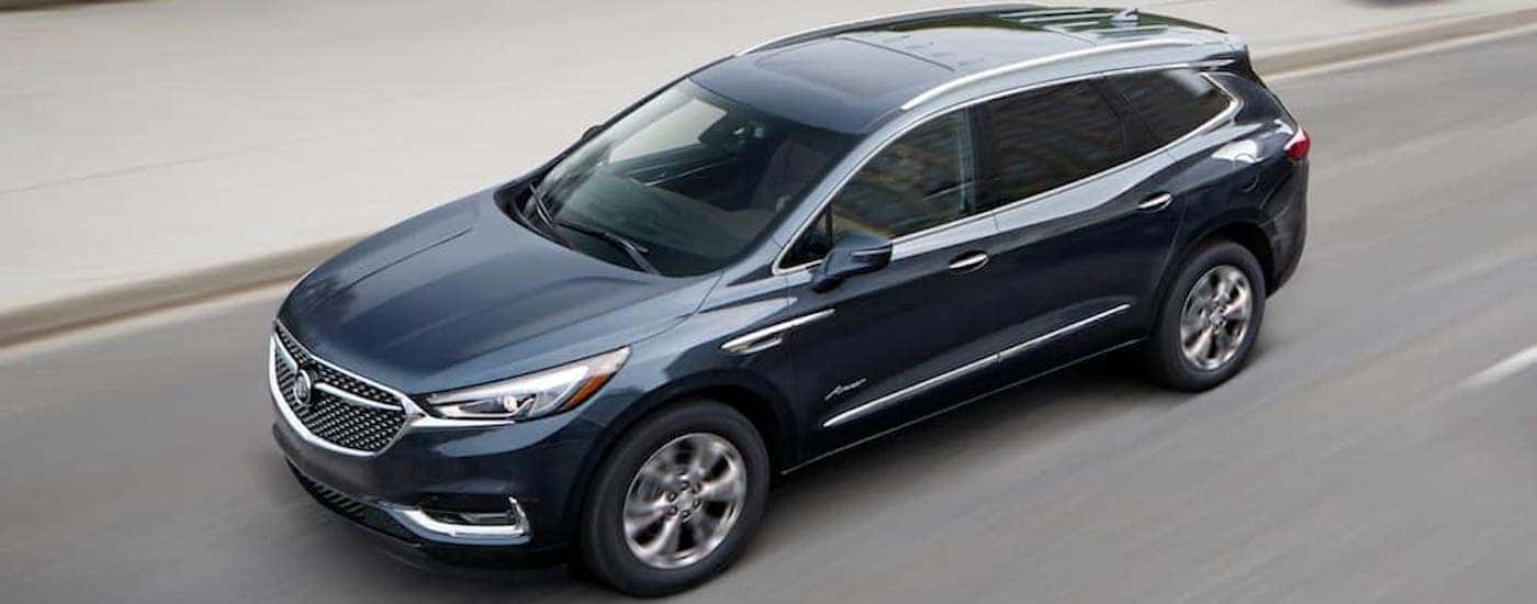 A dark blue 2019 Buick Enclave is shown from a high angle on a highway.